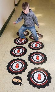 Elementary student walks on a sensory floor.